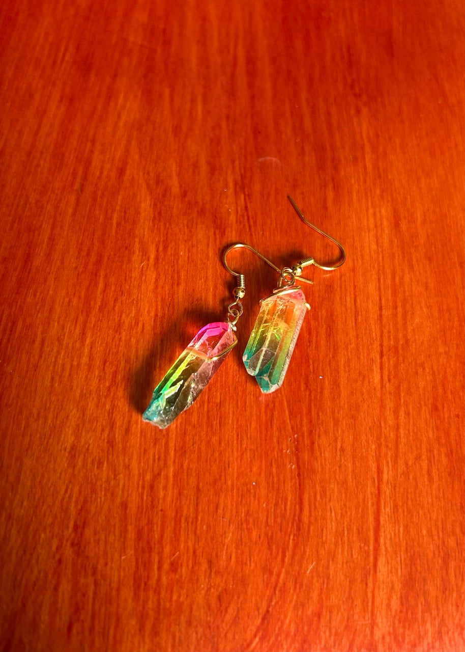 Rainbow crystal earrings with gold color fishhook earwire on a wooden surface.