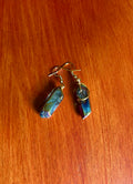 Crystal dangle earrings with a rainbow surface. Blue and gold are the dominant colors. Gold wire is used to attach the crystals to gold fishhook earwires.